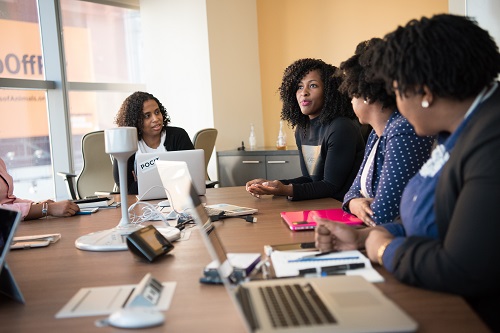 five woman at the conference room discussing steps to Prepare presentation