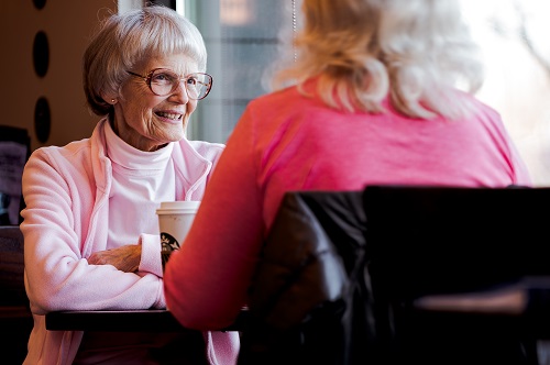 an old woman sitting while talking with another woman about steps to to Prepare presentation