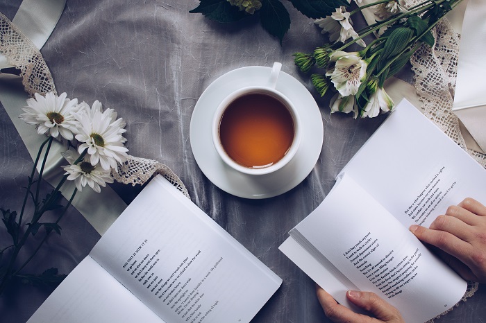 white ceramic teacup with saucer near two books above gray improving reading skills