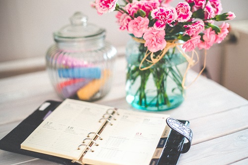 pink flowers and a diary displaying basic organizational plan
