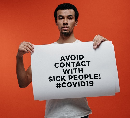 a man holding banner showing safety measures against coronavirus