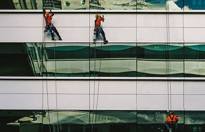 workers going up the building on ropes showing workplace safety hazards