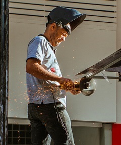 worker cutting iron for workplace safety hazards