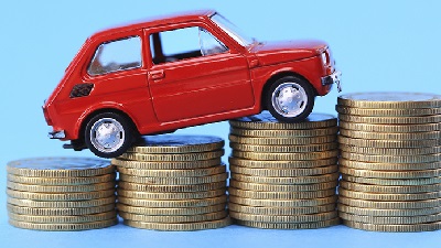 a red car climbing on coins to show How to save money on car insurance 