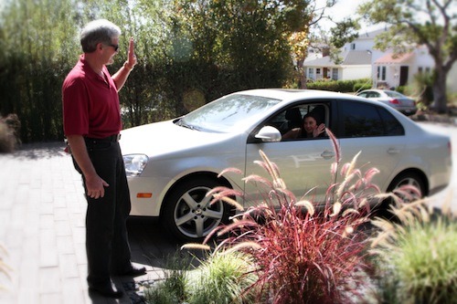 man waving to a woman in the car showing 8 things to know about auto insurance