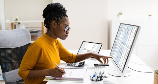 A woman in yellow in front of a screen showing Health Plan Costs for 2021