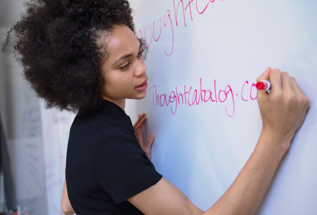 girl writing on white board Education-Trends-2020-to-2021