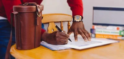 10 Power Tips for Writing a Book 1 two hands with a pen and a note book writing Power Tips for writing